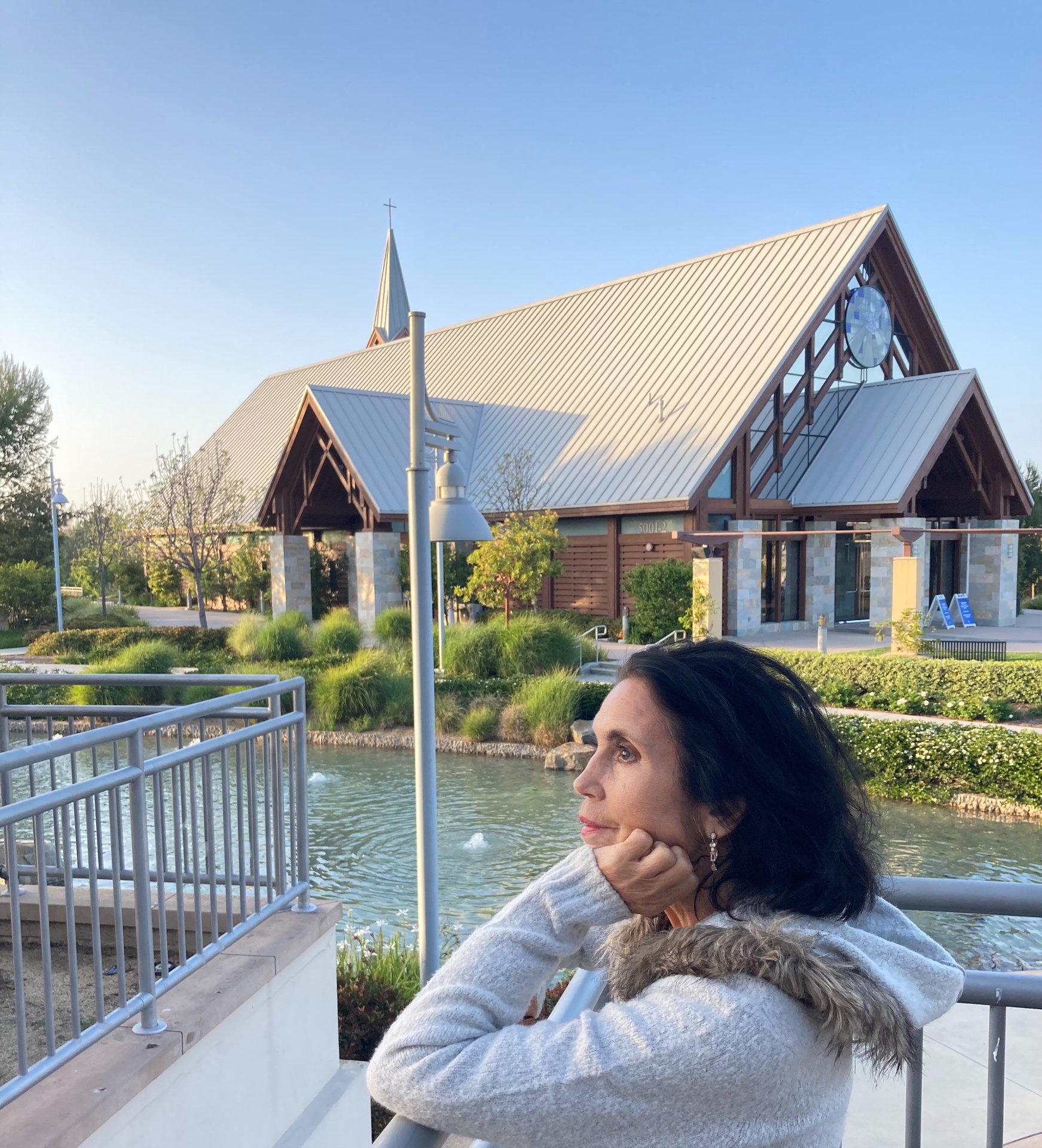 Elena at Mariners Church, resting on the railing by the pond in front of the chapel